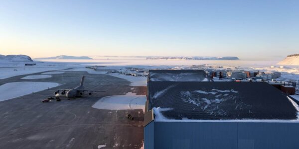 Pituffik Space Base tarmac, hangars, base facilities, and a US C-17 cargo aircraft, set amidst the frozen winter wilderness of Northern Greenland. Photo: David Palmer