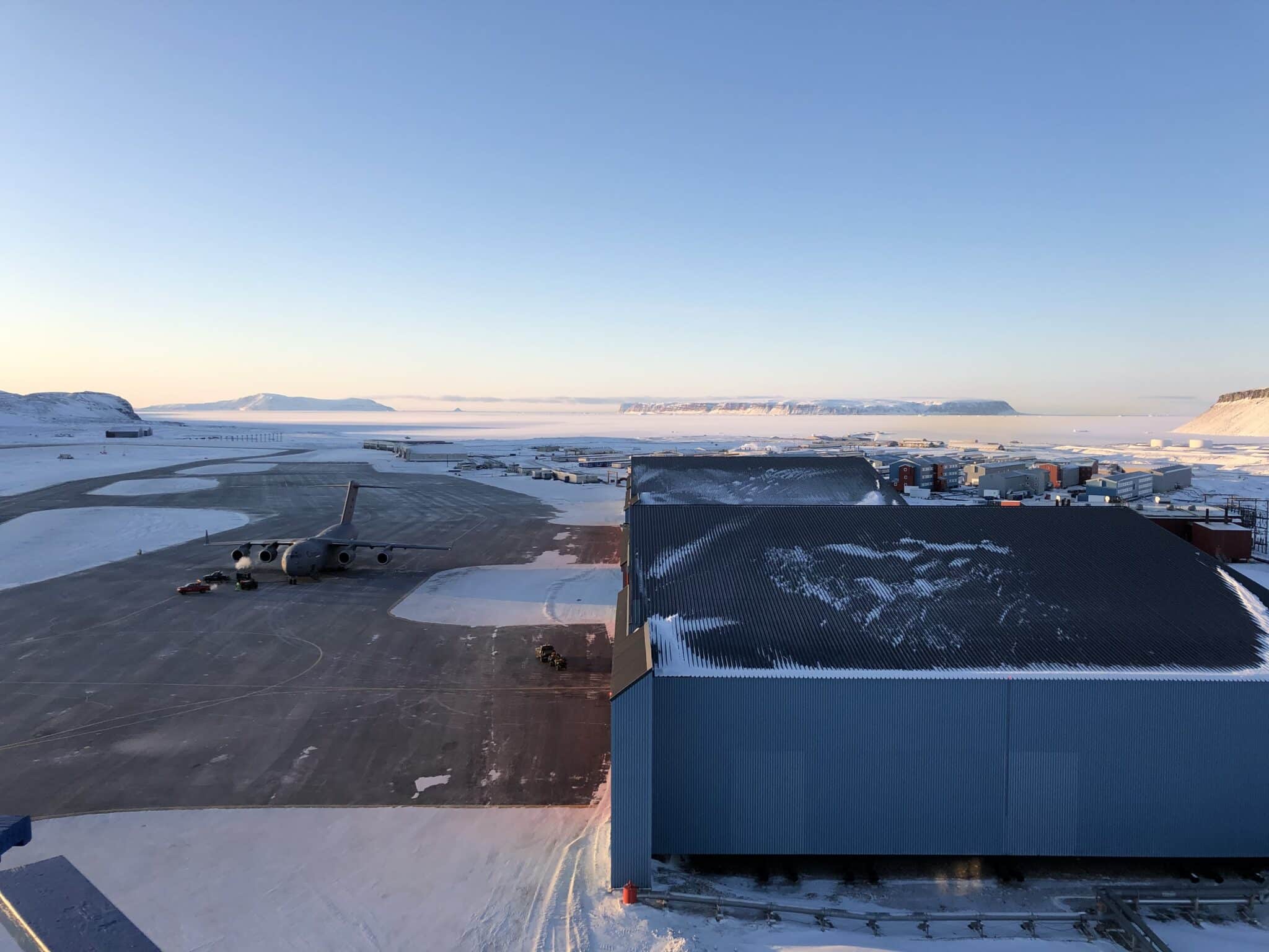 Pituffik Space Base tarmac, hangars, base facilities, and a US C-17 cargo aircraft, set amidst the frozen winter wilderness of Northern Greenland. Photo: David Palmer