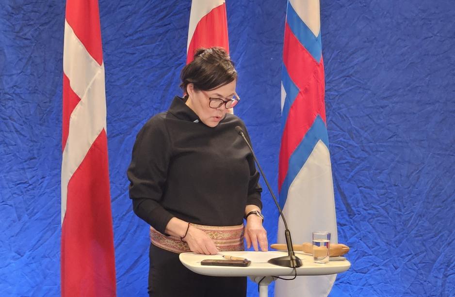 Denmark's work in the Arctic Council will be led from Greenland. Here, Greenland's Foreign Minister, Vivian Motzfeldt, is in front of the Danish, Greenlandic, and Faroese flags. (Photo: Arne O. Holm)