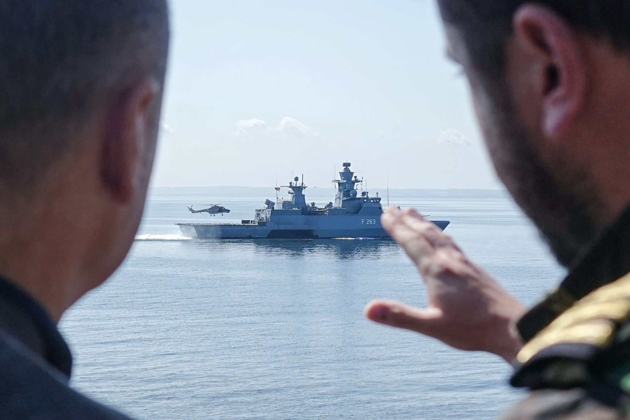 German Chancellor Olaf Scholz speaks with a serviceman as he stands aboard the frigate Mecklenburg-Vorpommern during his visit of the German Navy during a military maneuver in the Baltic Sea near Rostock-Warnemünde, northeastern Germany, on June 5, 2023. Photo: AFP