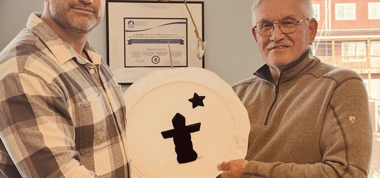 Harry Flaherty, right, CEO of Qikiqtaaluk Corporation, gives Glen Cowan, founder of ONE9, an Inuit drum Oct. 17 as a symbol of their partnership. The pair have joined together to create Sapujjijiit Inc., what they say is the first Inuit-owned defence company. (Photo courtesy of ONE9)