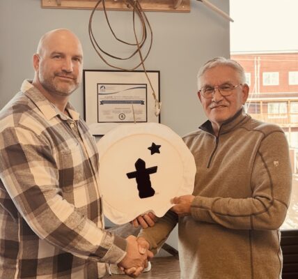 Harry Flaherty, right, CEO of Qikiqtaaluk Corporation, gives Glen Cowan, founder of ONE9, an Inuit drum Oct. 17 as a symbol of their partnership. The pair have joined together to create Sapujjijiit Inc., what they say is the first Inuit-owned defence company. (Photo courtesy of ONE9)