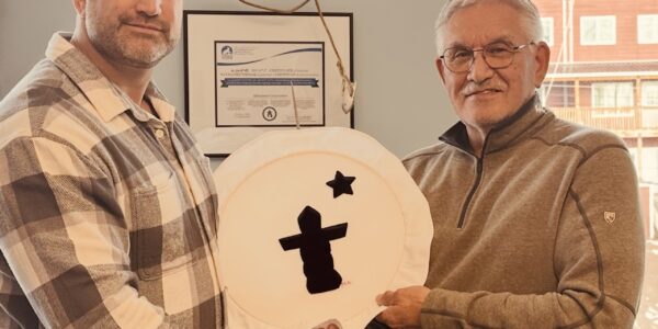 Harry Flaherty, right, CEO of Qikiqtaaluk Corporation, gives Glen Cowan, founder of ONE9, an Inuit drum Oct. 17 as a symbol of their partnership. The pair have joined together to create Sapujjijiit Inc., what they say is the first Inuit-owned defence company. (Photo courtesy of ONE9)