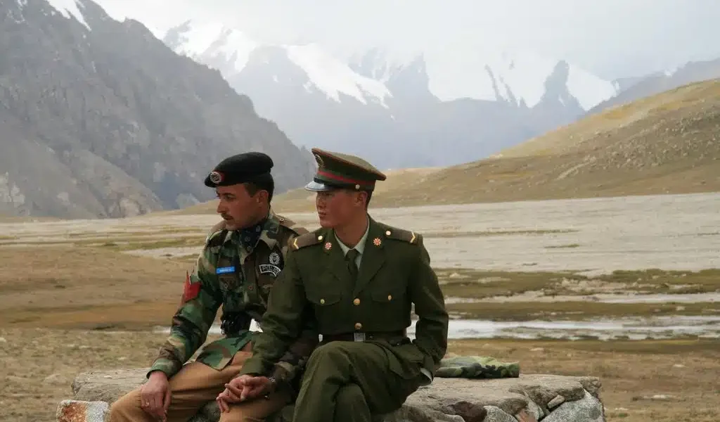 Chinese and Pakistani border guards clasp hands at the Karakoram Highway’s Khunjerab Pass, the highest paved international border crossing globally. Photo: Anthony Maw