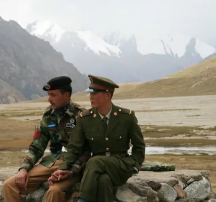 Chinese and Pakistani border guards clasp hands at the Karakoram Highway’s Khunjerab Pass, the highest paved international border crossing globally. Photo: Anthony Maw