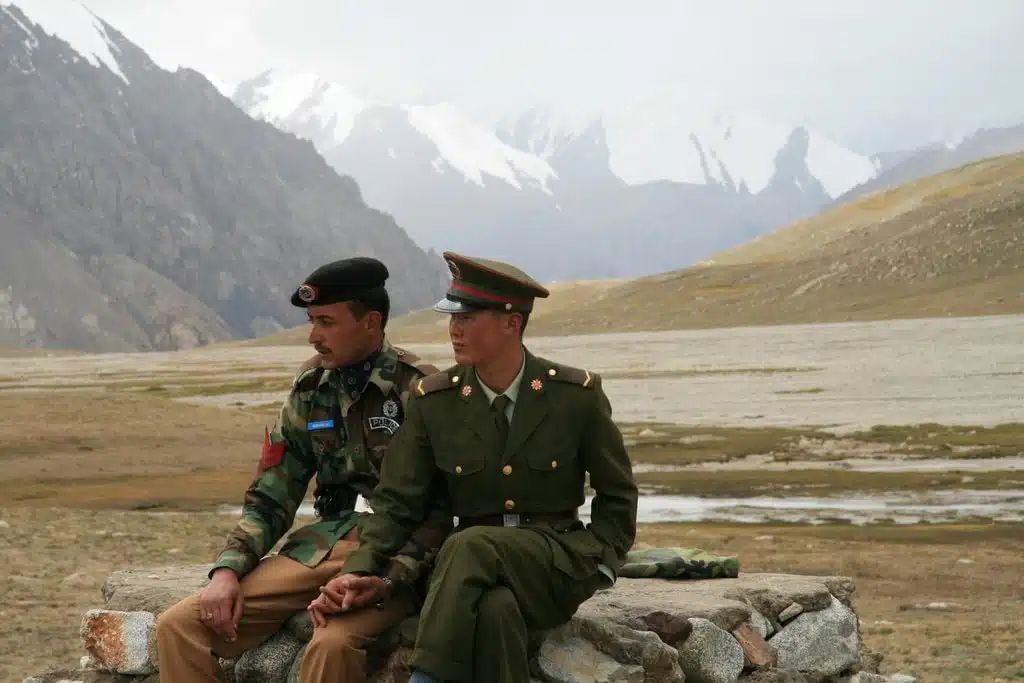 Chinese and Pakistani border guards clasp hands at the Karakoram Highway’s Khunjerab Pass, the highest paved international border crossing globally. Photo: Anthony Maw