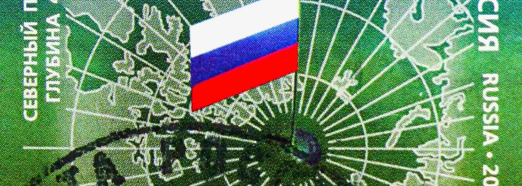Postage stamp printed in Russia shows a mirrored map of the Arctic, with Russian flag on the North Pole. Credit: Alexander Mitrofanov