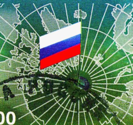 Postage stamp printed in Russia shows a mirrored map of the Arctic, with Russian flag on the North Pole. Credit: Alexander Mitrofanov