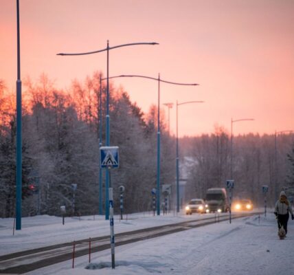 A woman walks her dog in Ivalo, Finnish Lapland. Maintaining 24-hour emergency care here was among the measures decided on Monday. (Jonathan Nackstrand/AFP via Getty Images)
