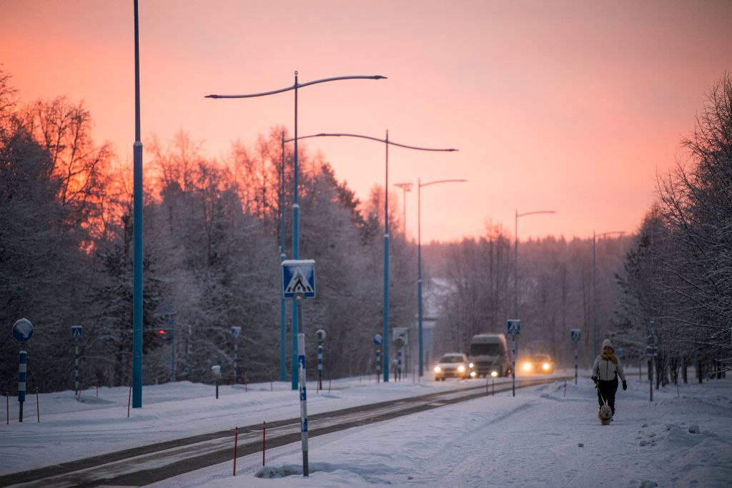 A woman walks her dog in Ivalo, Finnish Lapland. Maintaining 24-hour emergency care here was among the measures decided on Monday. (Jonathan Nackstrand/AFP via Getty Images)